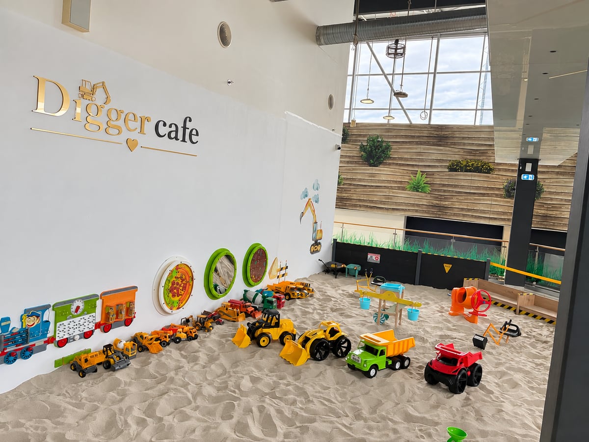 Pískoviště s bagry a tatrovkami pod logem Digger cafe